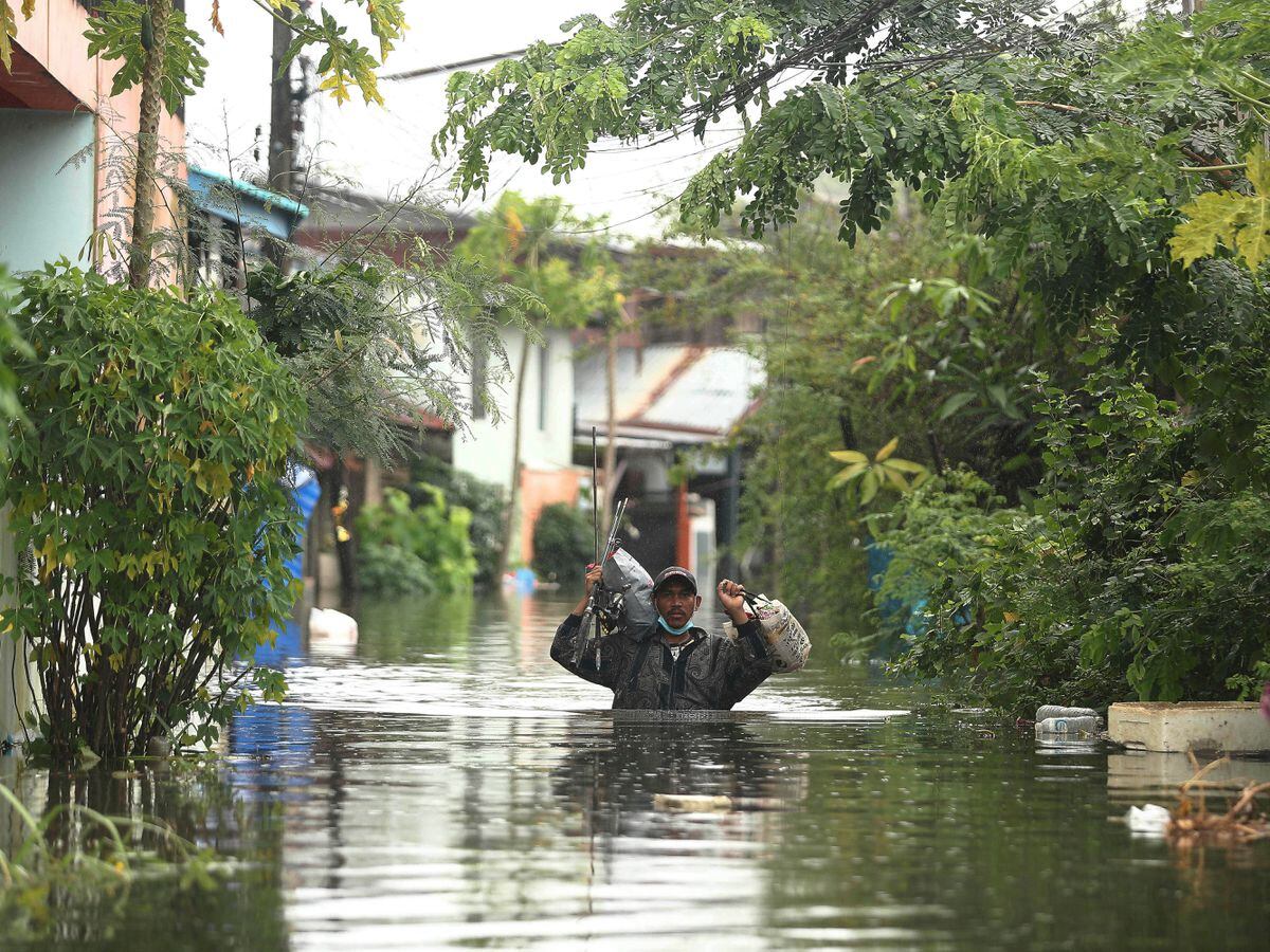 A resident wades through floodwaters in the Ubon Ratchathani province, north-eastern Thailand