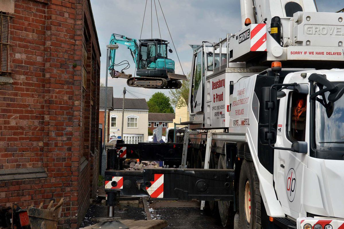 A mini digger is craned in to be used in the work