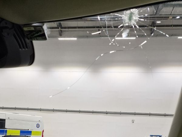 The smashed windscreen of the West Midlands Police patrol car after it was hit by a brick. Photo: West Midlands Police