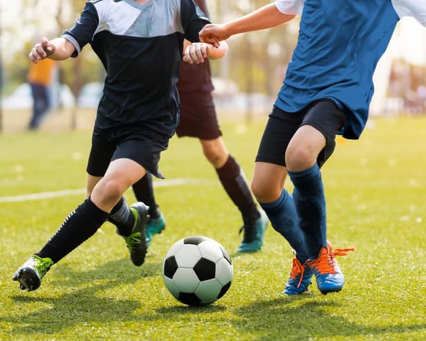 Legs of two young football players on a match.